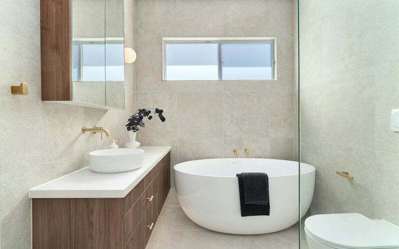 Phòng tắm ốp gạch với lavabo đặt bàn và bồn tắm